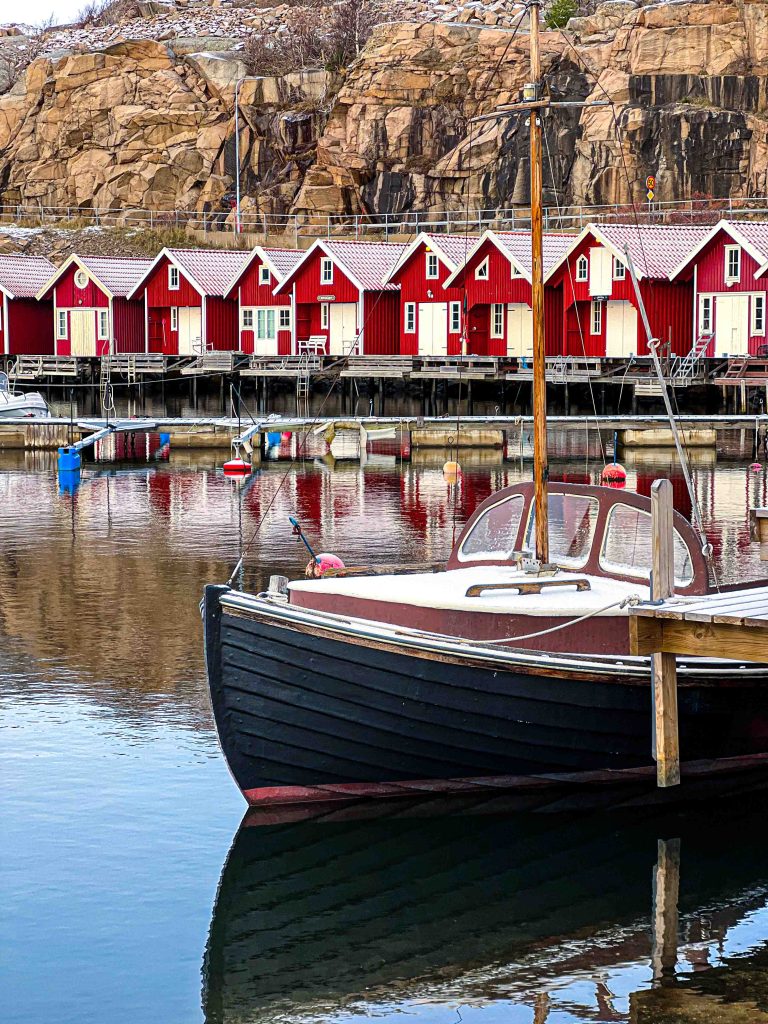 Bild på båt framför sjöbodar